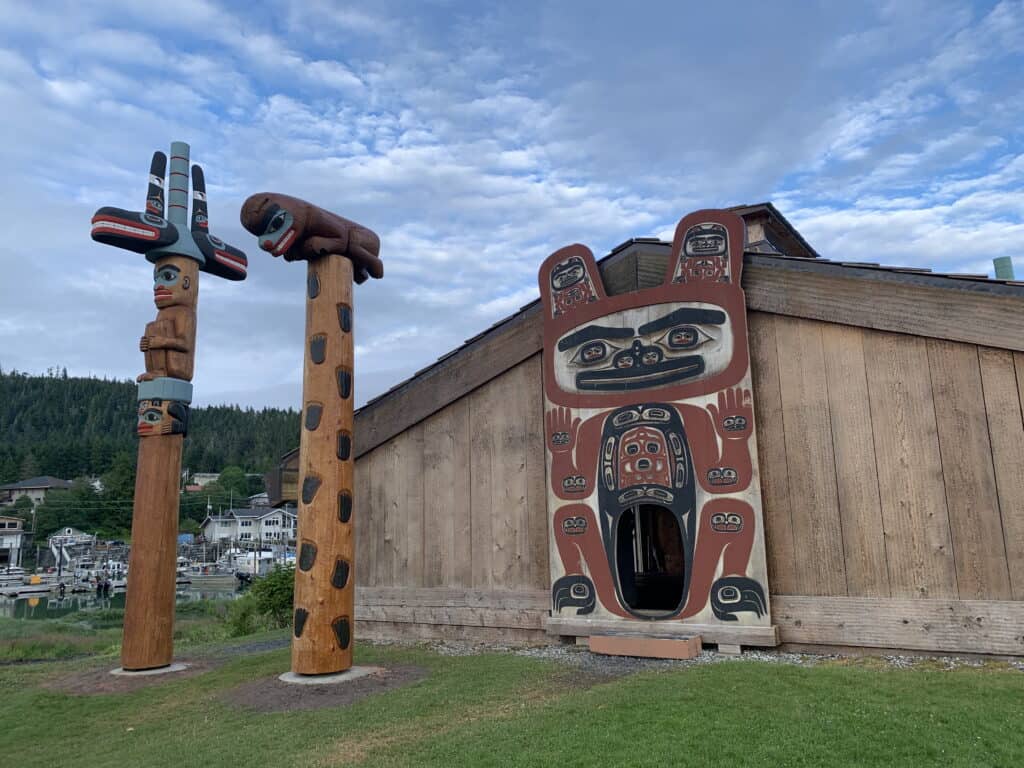 
Bear Up the Mountain Totem Pole
Tells the story of the Naanya.aayí X’atgu Hít survival during a great flood by following the bear up the mountain. The pole was originally restored in 1940 by the Civilian Conservation Corps (CCC). The Bear Up the Mountain totem pole was re-carved by Haida master carver Joe Young. A team of apprentices supported Joe Young including Mike Hoyt, Tony Harding and Linda Churchill. It raised in July 2025.
